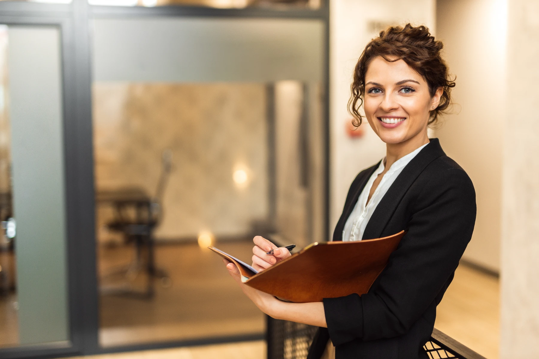 Smiling Woman in Business Attire Holding a Folder